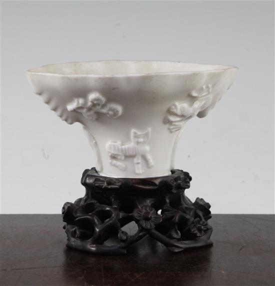 A Chinese Dehua blanc-de-chine libation cup, late 17th / early 18th century, 13cm, carved wood stand